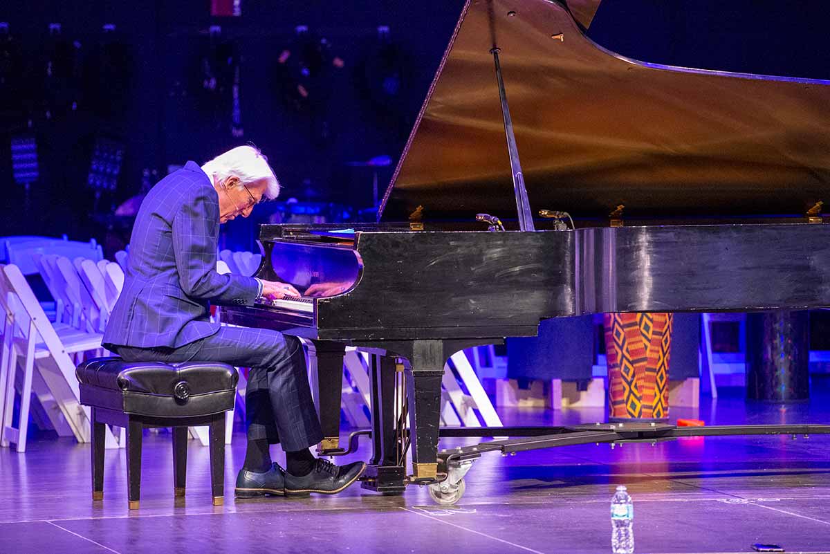 Larry Livingston performing on the piano for a keynote speech.